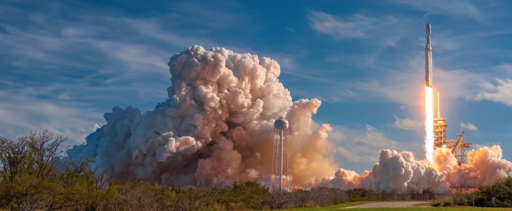space x rocket launch with cloud of smoke